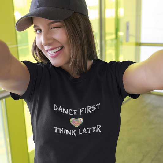 Person wearing a black t-shirt with 'Dance First, Think Later' text and a heart symbol.