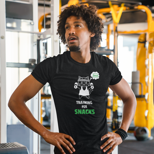 Man wearing a black "Training for Snacks" t-shirt with a graphic design in a gym setting