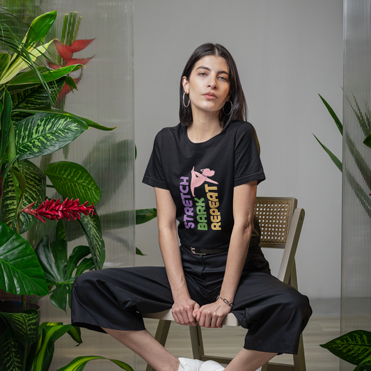 Woman wearing black yoga tee with "Stretch bark repeat" 
