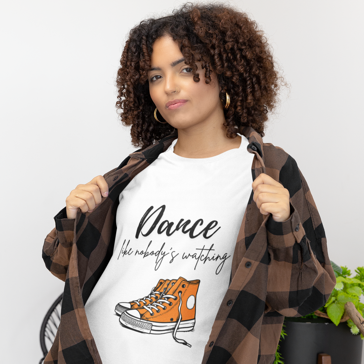 Woman wearing white unisex dance t-shirt with the phrase “Dance Like Nobody’s Watching”. A carefree and uplifting design for those who dance freely and unapologetically.