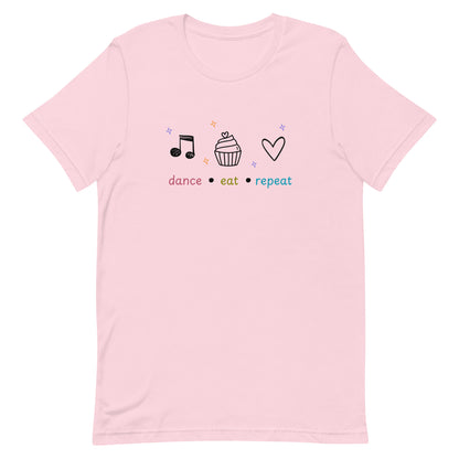 Soft pink dance t-shirt featuring dance eat repeat text with black icons of a music note, cupcake, and heart, designed for fun-loving dancers.