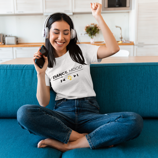 White unisex Dance Mood On t-shirt featuring black and yellow print, modeled by a woman listening to music indoors