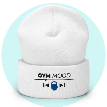 White cuffed beanie from the Gym Mood On collection with embroidered text and blue kettlebell icon, displayed on a light blue background.