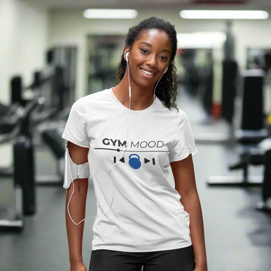 White unisex Gym Mood On t-shirt featuring kettlebell graphic, modeled by a woman with headphones in a gym