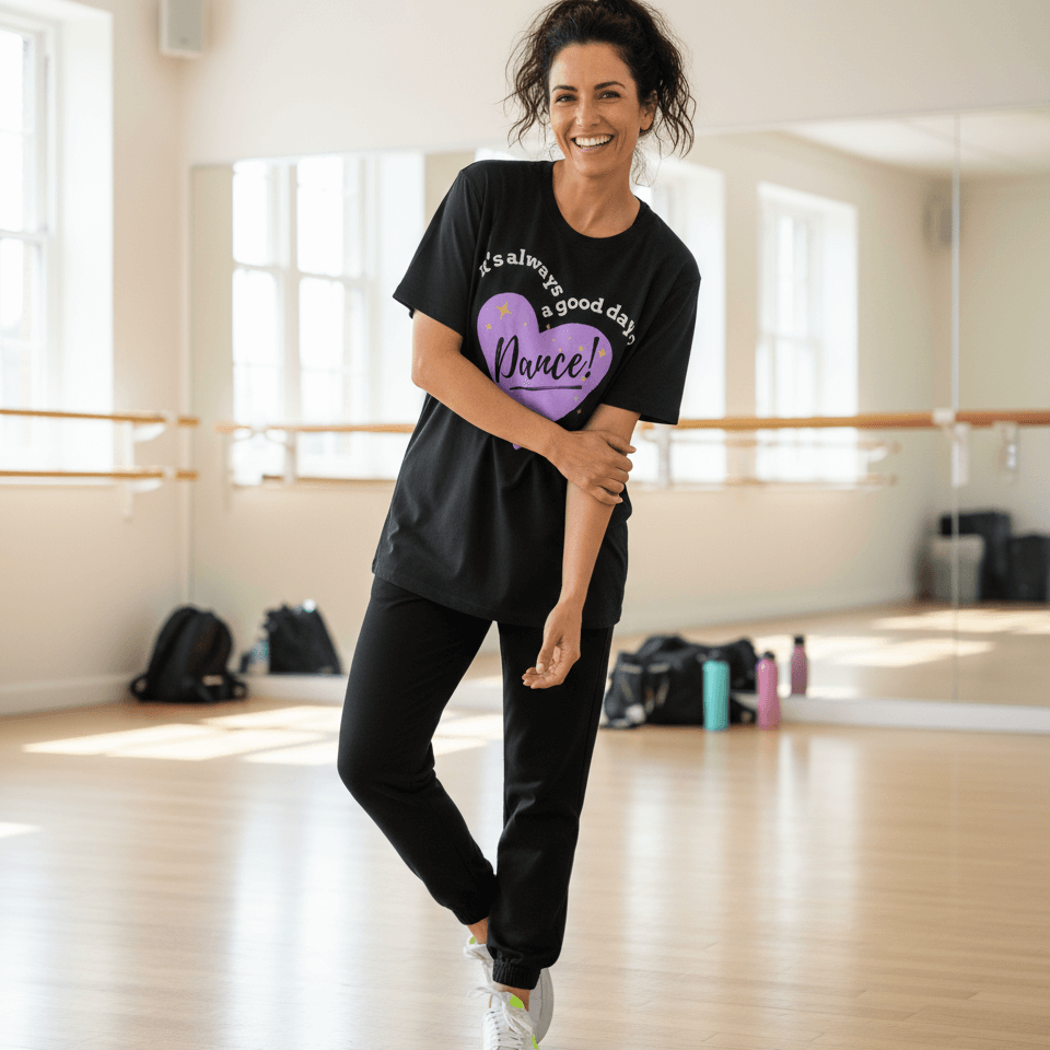 Woman smiling in a dance studio wearing a black “It’s Always a Good Day to Dance” t-shirt from MM Tee Lab